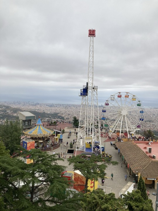 Rides at the Tibidabo amusement park on the hilltop, with Barcelona spread out below